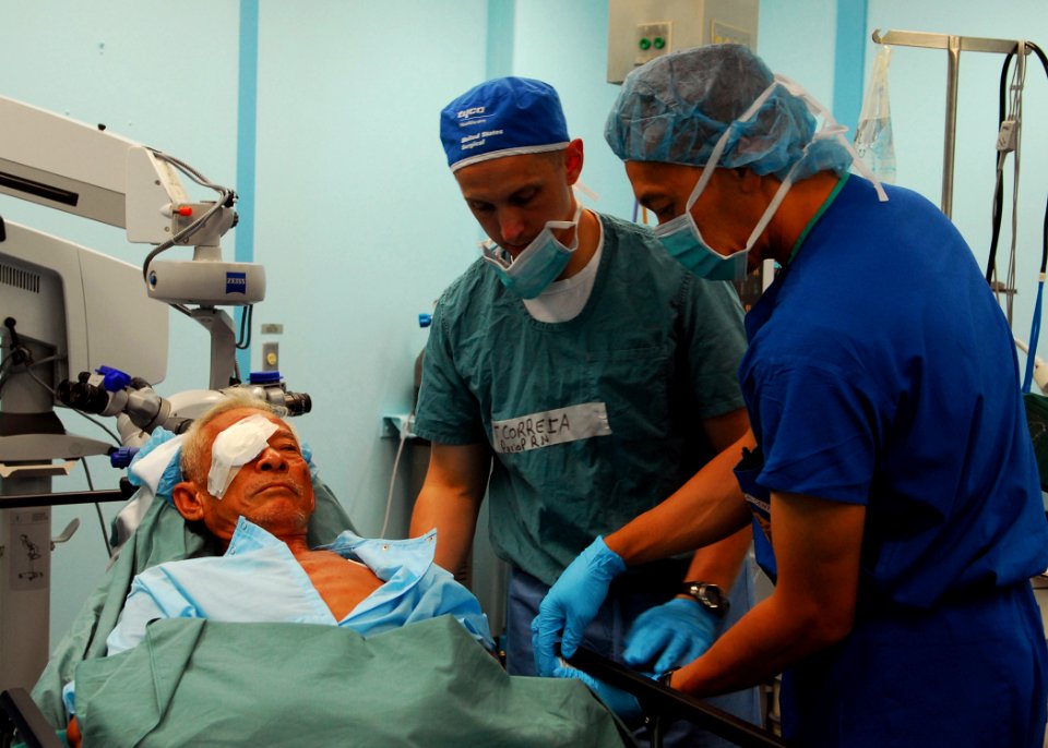 US Navy 100604-N-4044H-047 Medical personnel adjust the bed of a Vietnamese patient after cataract surgery aboard Mercy