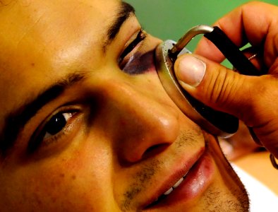 US Navy 081012-N-5345W-026 Mass Communication Specialist 3rd Class Ronald Dallatorre, assigned to the aircraft carrier USS Abraham Lincoln (CVN 72) has his black eye tended by a USA Boxing staff member photo