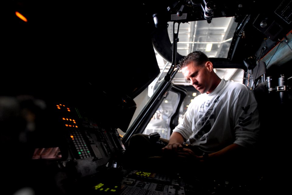 US Navy 081016-N-3610L-037 Aviation Electrician's Mate 1st Class Ryan Lontos checks the stabilizing systems in the cockpit of an SH-60F Seahawk helicopter assigned to the