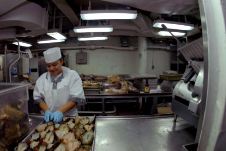 US Navy 081013-N-3610L-093 Culinary Specialist Seaman Recruit Charlene Cruz de-shells a batch of lobster tails in the aft mess decks aboard the Nimitz-class aircraft carrier USS Ronald Reagan (CVN 76) photo