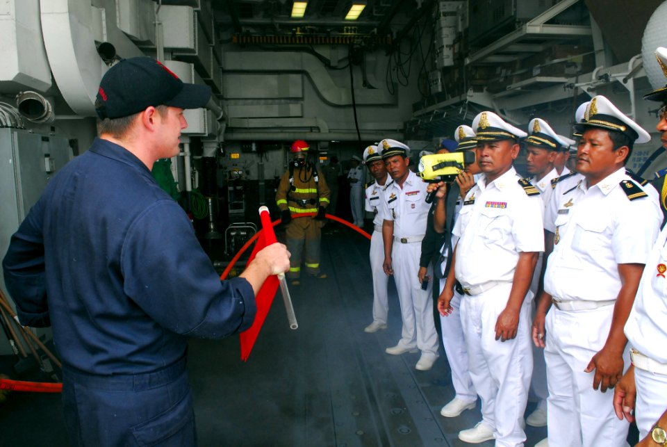 US Navy 081014-N-2013O-006 Damage Controlman 1st Class Robert Lyons explains the purpose of flags used during damage control drills to sailors of the Royal Cambodian navy