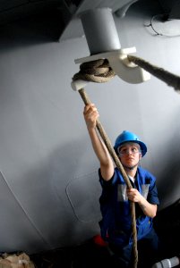US Navy 081015-N-3610L-063 Boatswain's Mate Seaman Ana Orozco uses a ceiling chock to secure a re-mating line in fuel replenishment station 9 aboard the Nimitz-class aircraft carrier USS Ronald Reagan (CVN 76)