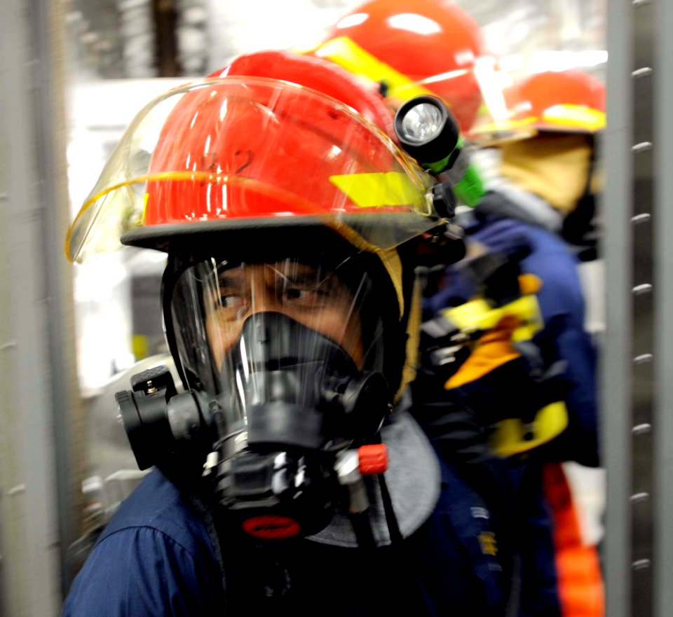 US Navy 100327-N-7653W-154 Chief Operation Specialist Anthony Morales help Sailors contain a fire during a damage control training drill