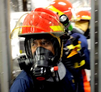 US Navy 100327-N-7653W-154 Chief Operation Specialist Anthony Morales help Sailors contain a fire during a damage control training drill