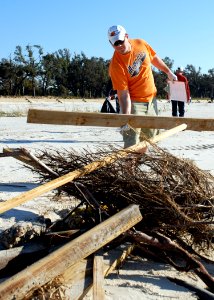 US Navy 081018-N-3857R-002 Construction Mechanic 2nd Class Karl Cox, assigned to Naval Mobile Construction Battalion (NMCB) 1, gathers storm debris off the beach in Gulfport, Miss