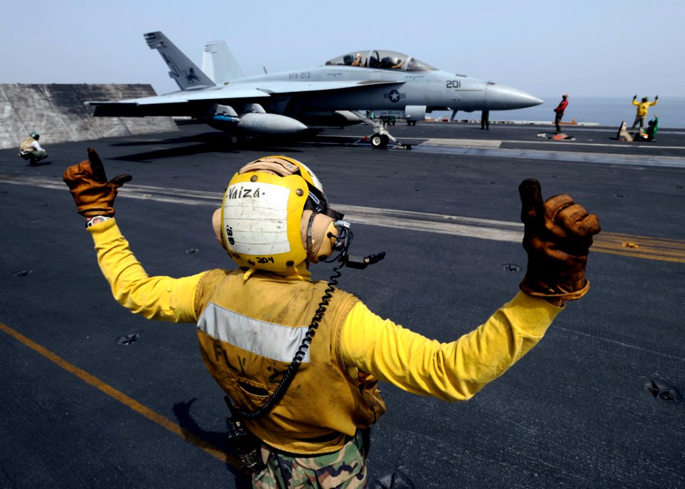 US Navy 081016-N-7241L-019 Aviation Boatswain's Mate 3rd Class Stephen Vaiza communicates with the pilots of an F-A-18F Super Hornet strike fighter assigned to the