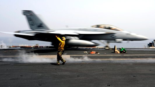 US Navy 081016-N-7241L-060 Aviation Boatswain's Mate 3rd Class Stephen Vaiza directs an aircraft as an f-A-18F Hornet strike fighter launches off the aircraft carrier USS Theodore Roosevelt (CVN 71)