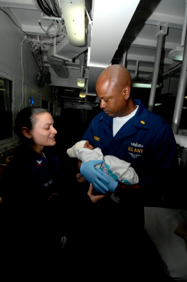 US Navy 100129-N-8936G-004 Lt. Raynard Gibbs passes a newborn baby girl to Hospital Corpsman 2nd Class Eunite Merle