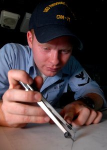 US Navy 081015-N-2456S-051 Quartermaster 3rd Class Colin Lalor plots ship's course and speed while standing watch as quartermaster of the watch on the bridge of the aircraft carrier USS Theodore Roosevelt (CVN 71)