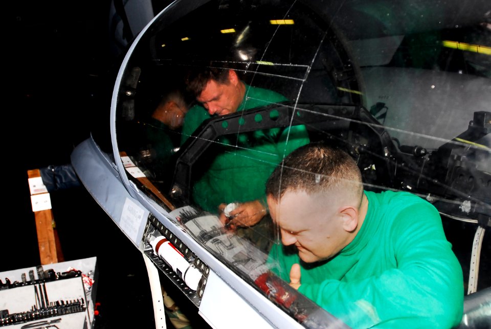 US Navy 081018-N-9610C-026 Aviation Structural Mechanic (Equipment) Airman Baxton Pickett and Aviation Structural Mechanic (Equipment) 1st Class Richard Harring repair the inside of an F-A-18F Super Hornet canopy