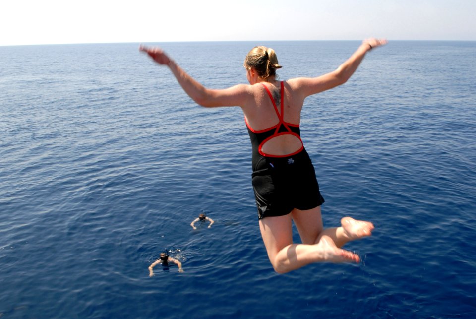 US Navy 081016-N-1635S-004 Quartermaster Seaman Sarah Mills leaps off the Ticonderoga-class guided-missile cruiser USS Chancellorsville (CG 62) during a scheduled swim call