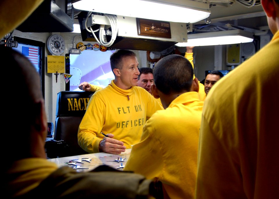 US Navy 081018-N-6676S-003 Lt. Ronald Rancourt, flight deck officer aboard the aircraft carrier USS Theodore Roosevelt (CVN 71), discusses the day's flight operations with aircraft handlers in Flight Deck Control
