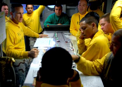 US Navy 081018-N-6676S-017 Lt. Ronald Rancourt, flight deck officer aboard the aircraft carrier USS Theodore Roosevelt (CVN 71), discusses the day's flight operations with aircraft handlers in Flight Deck Control