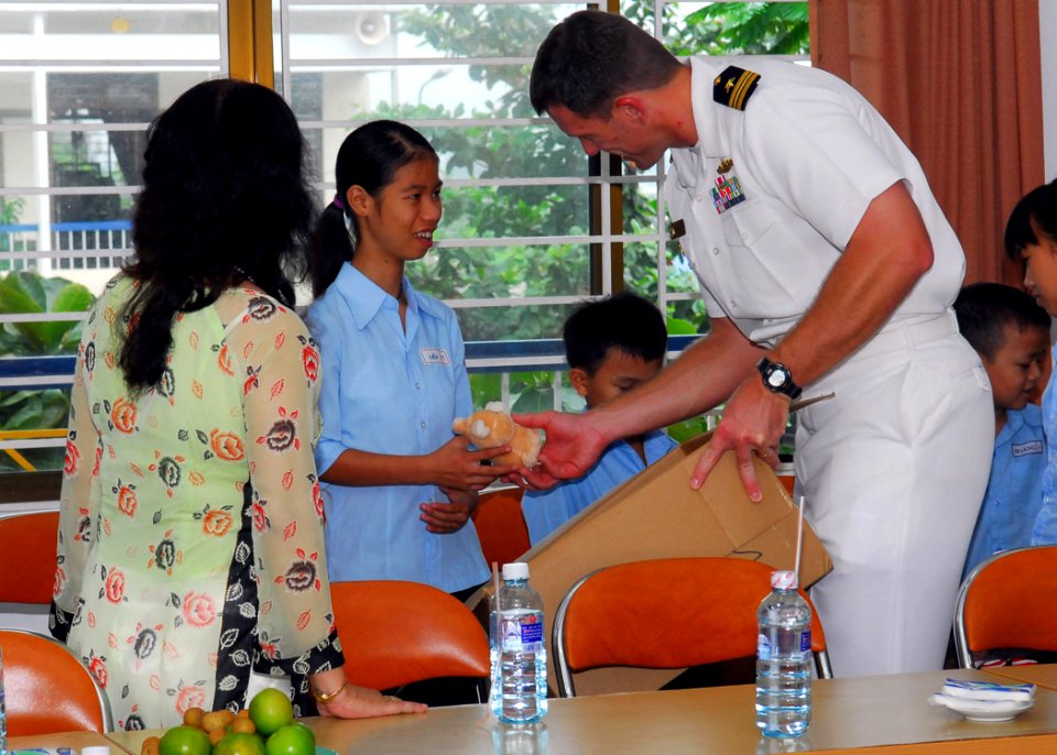 US Navy 081019-N-2013O-004 Lt. Cmdr. Donald Marks, executive officer of the guided-missile destroyer USS Mustin (DDG 89), gives a stuffed animal to a student