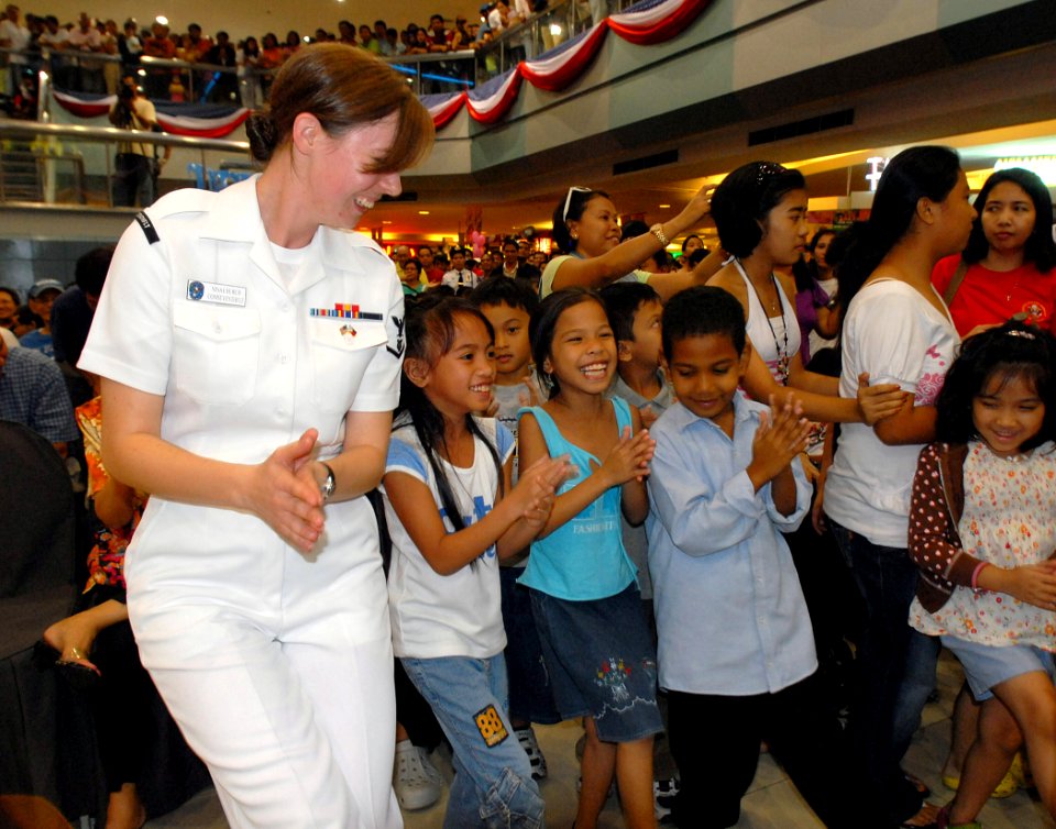US Navy 090222-N-1113S-003 Musician 3rd Class Nina Church leads children in a dance at the SM City North EDSA Mall