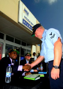 US Navy 081020-N-0780F-002 Best selling author and financial journalist Kelvin Boston shakes hands with Aviation Boatswain's Mate 2nd Class Keith Ewoldt