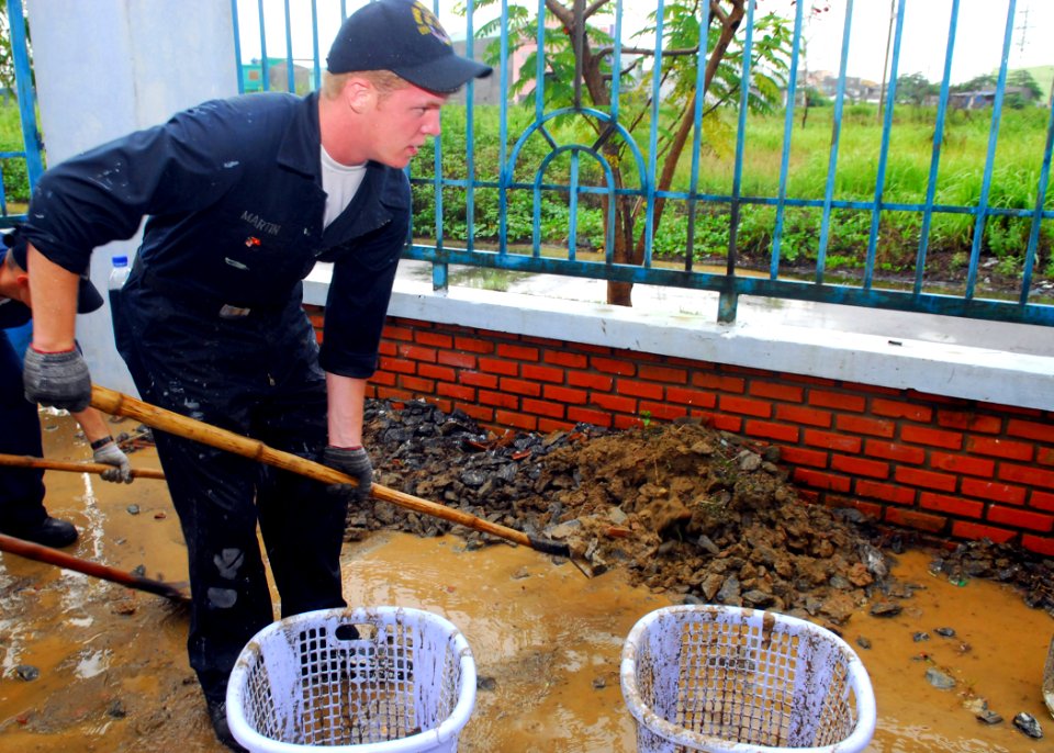 US Navy 081020-N-2013O-004 Seaman Dakota Martin, from Cottage Grove Minn. assigned to the guided-missile destroyer USS Mustin (DDG 89), performs yard work at the Nguyen Dinh Chieu School for Disabled Children