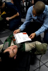 US Navy 081022-N-1635S-003 Hospital Corpsman David Small checks the status of a personnel casualty