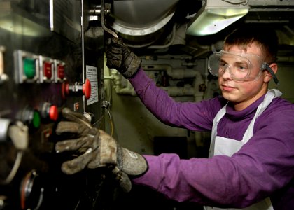 US Navy 081024-N-4954I-002 Aviation Boatswain's Mate (Fuel) Airman Scott McMahon operates a waste processing machine