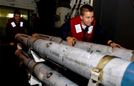 US Navy 081020-N-4954I-011 Aviation Ordnanceman Airman Robert West assists Aviation Ordnanceman 3rd Class Joshua Walker as he pushes training ordnance into the hangar bay of the Nimitz-class aircraft carrier USS John C. Stennis