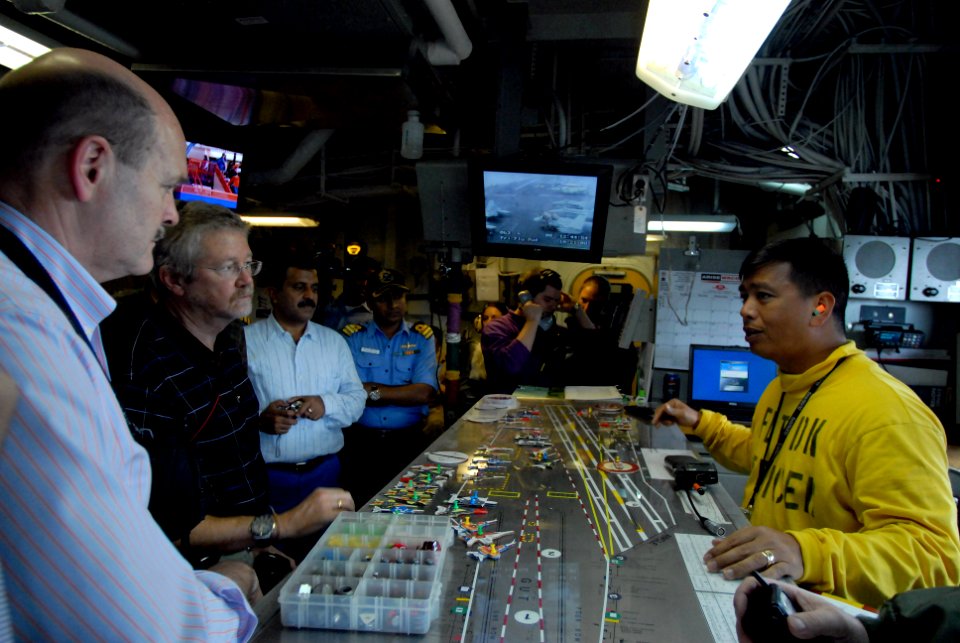 US Navy 081021-N-3610L-290 Lt. Ivan Borja, a flight deck officer aboard the Nimitz-class aircraft carrier USS Ronald Reagan (CVN 76), demonstrates how flight deck control utilizes the Ouija board to keep track of aircraft on th