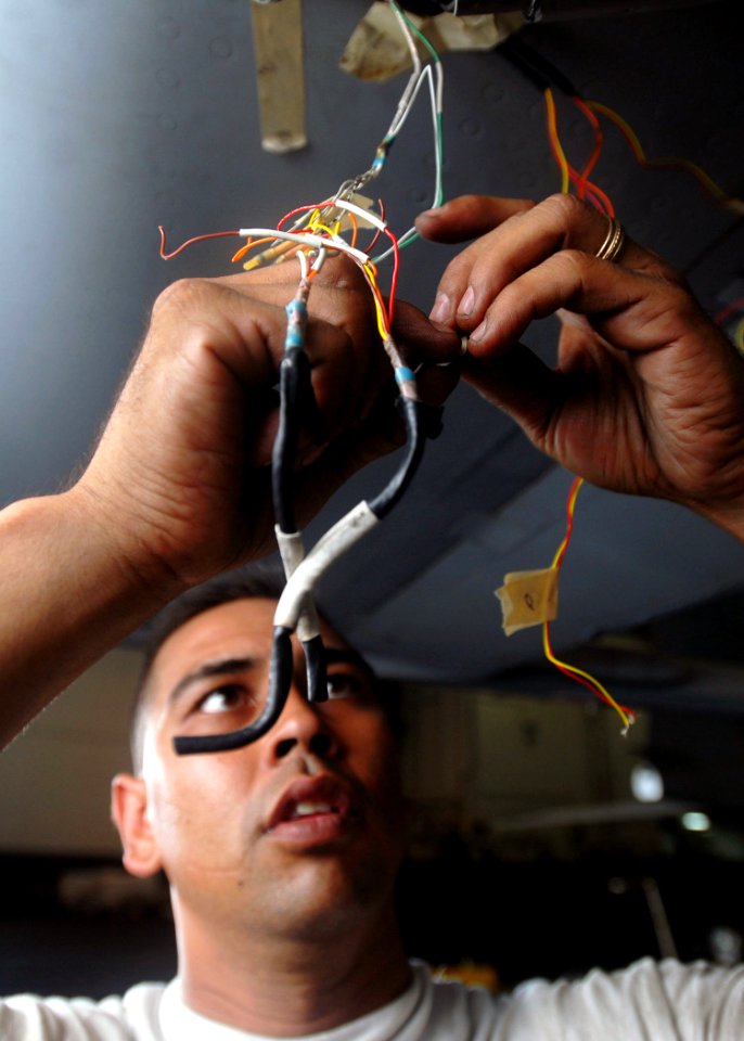 US Navy 081023-N-2456S-024 Aviation Electronics Technician 1st Class Joseph Robinson splices wires onto a strain gauge of an F-A-18C Hornet