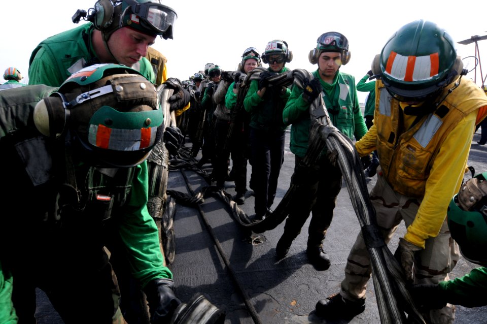 US Navy 081022-N-3659B-286 Sailors help stow the training barricade after completing a set of flight deck drills