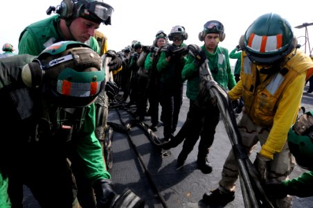 US Navy 081022-N-3659B-286 Sailors help stow the training barricade after completing a set of flight deck drills photo