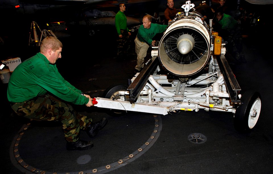 US Navy 081022-N-4954I-009 Aviation Machinist's Mate 3rd Class Daniel Pranzo maneuvers a turbo-jet engine from an EA-6B Prowler