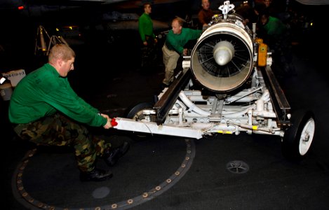 US Navy 081022-N-4954I-009 Aviation Machinist's Mate 3rd Class Daniel Pranzo maneuvers a turbo-jet engine from an EA-6B Prowler