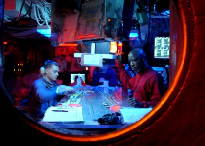 US Navy 081020-N-9565D-033 The night aircraft handling officer stops to study the current lay-out of the flight deck