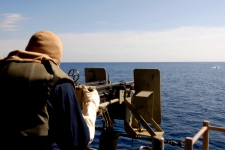 US Navy 081022-N-9520G-007 takes aim on a contact posing as a threat with a .50 cal. machine gun