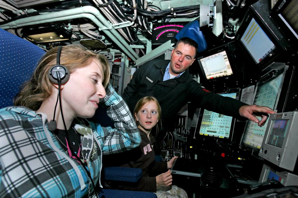 US Navy 081022-N-7441H-003 Sonar Technician 1st Class Billy Trowbridge points out several features of the control room to Elizabeth Godin and Elizabeth Palczynski