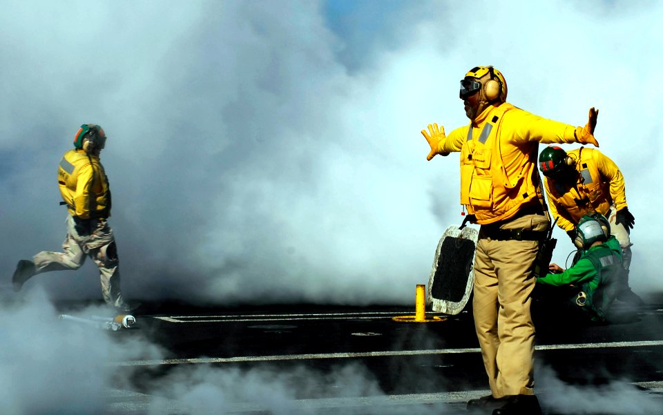 US Navy 081022-N-9928E-131 enior Chief Aviation Boatswain's Mate (Handling) Wilson Theodore, from New Orleans, directs an aircraft onto a catapult aboard the Nimitz-class aircraft carrier USS John C. Stennis (CVN 74)