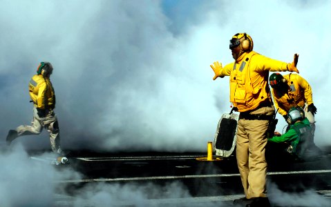 US Navy 081022-N-9928E-131 enior Chief Aviation Boatswain's Mate (Handling) Wilson Theodore, from New Orleans, directs an aircraft onto a catapult aboard the Nimitz-class aircraft carrier USS John C. Stennis (CVN 74)
