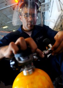 US Navy 081023-N-2456S-045 Damage Controlman Fireman Gregory Daves refills self contained breathing apparatus bottles