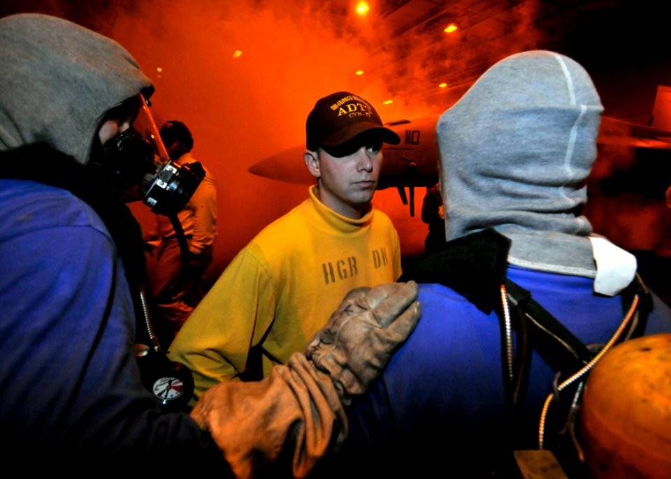 US Navy 081020-N-8534H-032 Aviation Boatswain's Mate 1st Class (Handling) Michael Walsh directs a fire fighting team aboard the aircraft carrier USS George Washington (CVN 73)