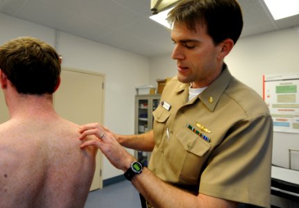 US Navy 081023-N-2959L-029 Lt. Cdmr. Shumaker examines a Sailor's back during a skin cancer screening photo
