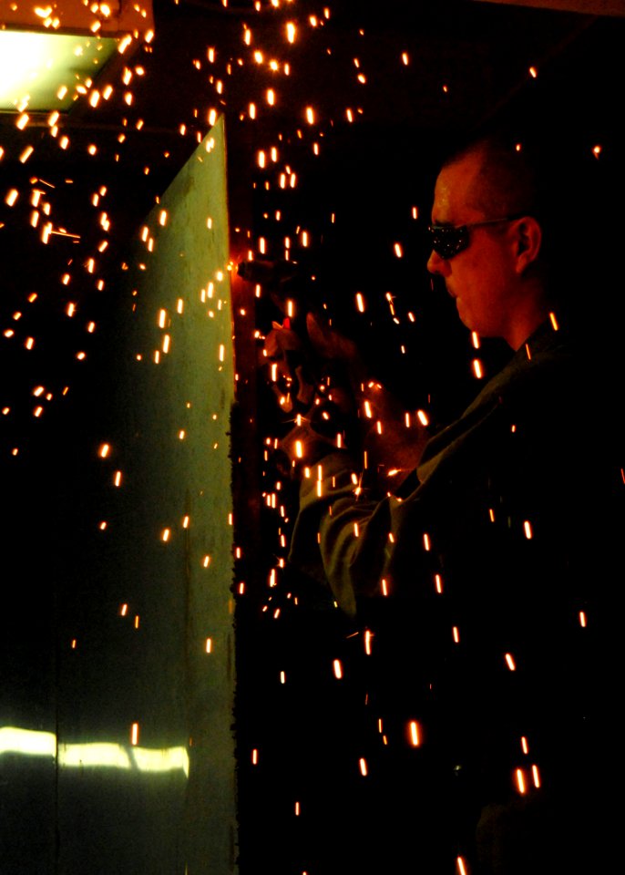 US Navy 081023-N-9900B-006 Hull Maintenance Technician 3rd Class Jon Frydenlund welds together a tool cage