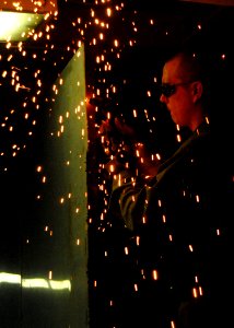 US Navy 081023-N-9900B-006 Hull Maintenance Technician 3rd Class Jon Frydenlund welds together a tool cage