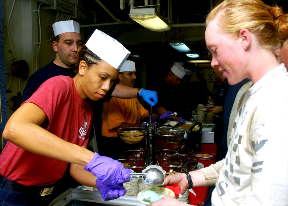 US Navy 081027-N-2456S-121 Electronics Technician 1st Class Nia Anthony scoops ice cream to Aviation Structural Mechanic 2nd Class Jessica Hayes