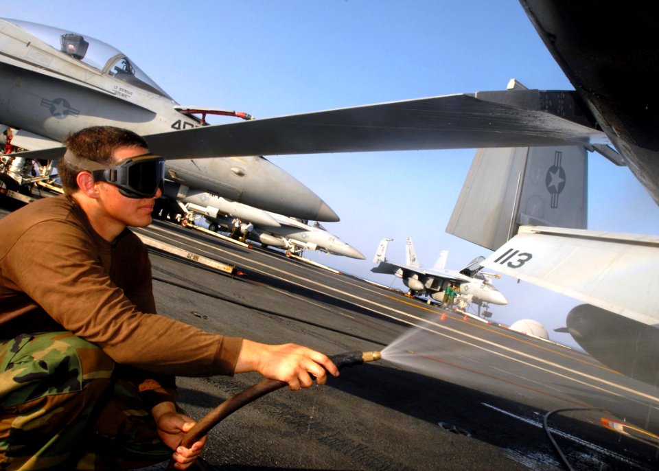 US Navy 081024-N-2456S-135 Aviation Structural Mechanic Airman Joshua Chacon sprays underneath an F-A-18E Super Hornet