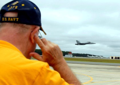 US Navy 081025-N-1522S-130 A spectator protects his ears as a F-A 18F Super Hornet performs at the 2008 Wings of Freedom Air Show
