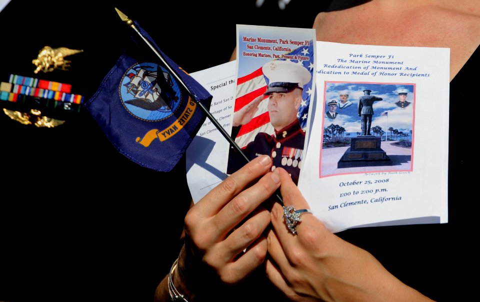 US Navy 081025-N-2959L-084 A spectator holds a program and a U.S. Navy flag during the Park Semper Fi Marine Monument re-dedication ceremony