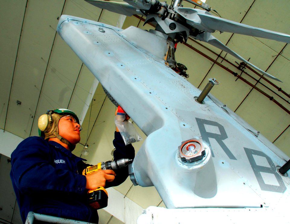 US Navy 081028-N-9689V-001 Aviation Electronics Technician 3rd Class Jimmy Hsueh removes a panel from the tail rotor of an MH-60S Sea Hawk helicopter