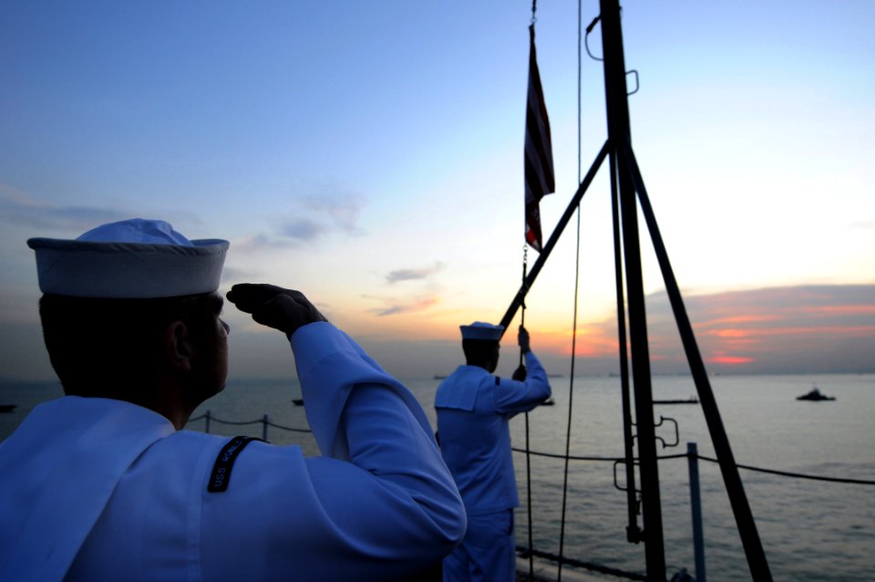 US Navy 081029-N-3659B-024 Sailors lower the Navy Jack
