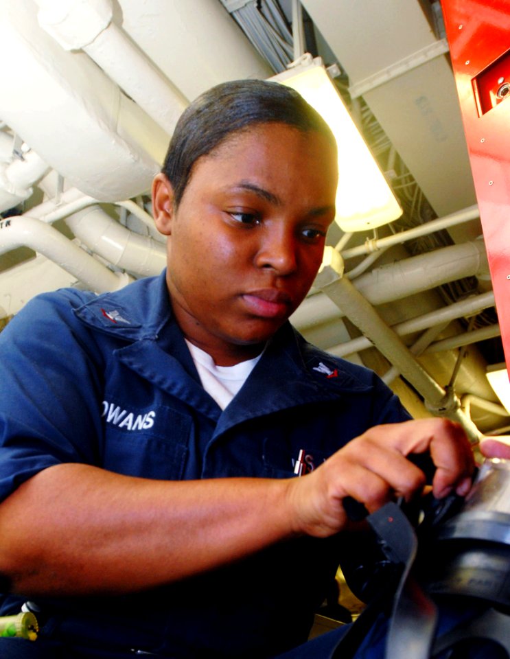 US Navy 081027-N-2456S-095 Damage Controlman 3rd Class Tosha Cowans places an adapter on the voice amplifier of the damage control facemask