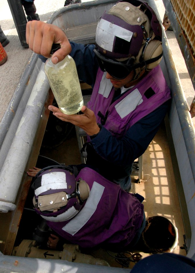 US Navy 081027-N-9134V-090 Engineman 2nd Class Jacob Martinez checks a fuel sample aboard the amphibious dock landing ship USS Carter Hall (LSD 50)