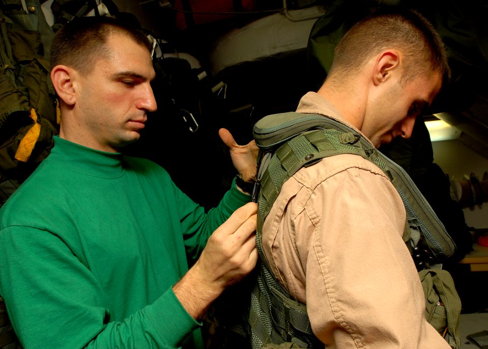 US Navy 081028-N-2456S-158 Aircrew Survival Equipmentman 2nd Class James Wilson assists Aviation Warfare Systems Operator 2nd Class Ian Hamlet, both assigned to the