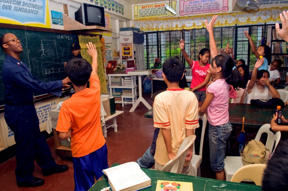 US Navy 081028-N-5253W-090 viation Warfare Systems Operator 2nd Class Darren Brown lays a game of hangman with students of the New Cabalan Elementary School